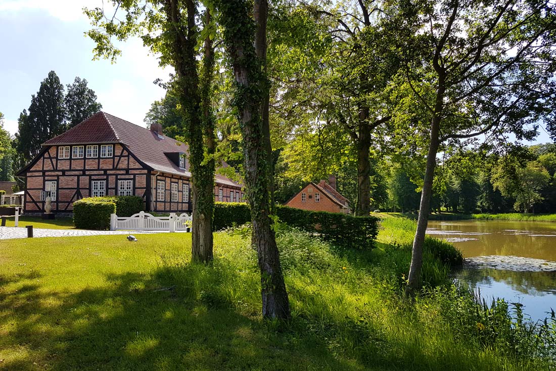 Fachwerkhaus mit Teich und Bäumen